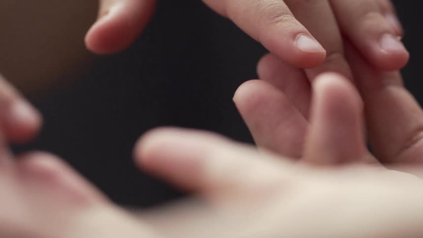 Persons hands touch babys hands
