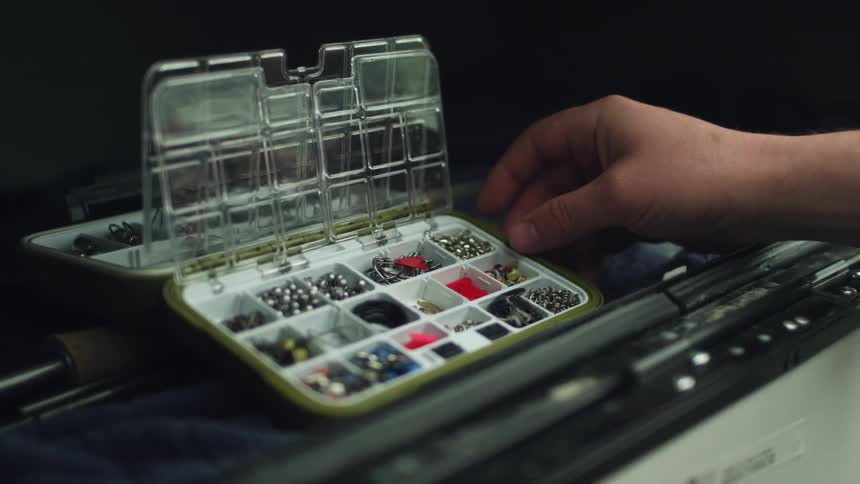 Man browses through bits in slots in small carrying case