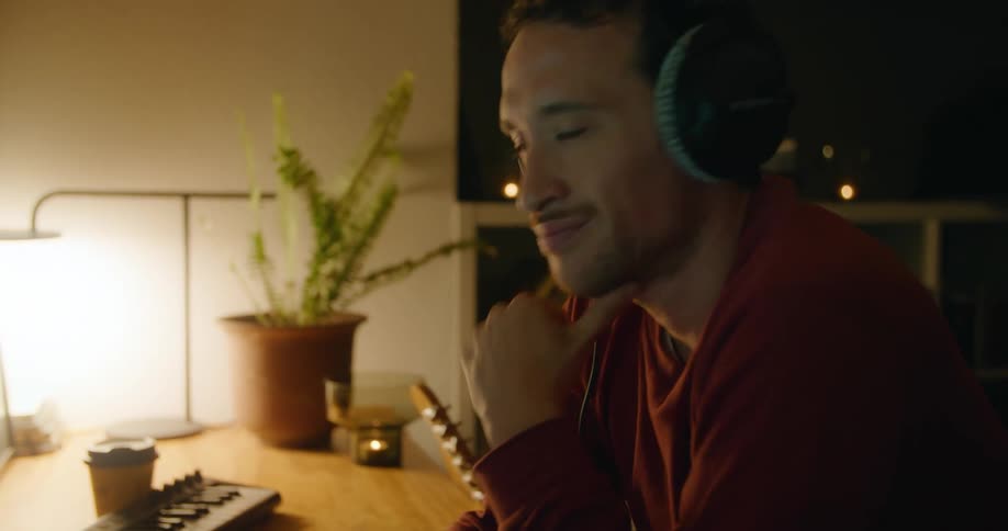 A man is listening to music at the computer