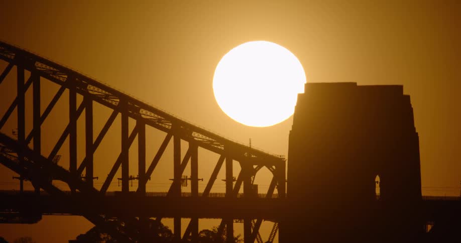 A silhouette of a bridge with the sunset and sky in the background