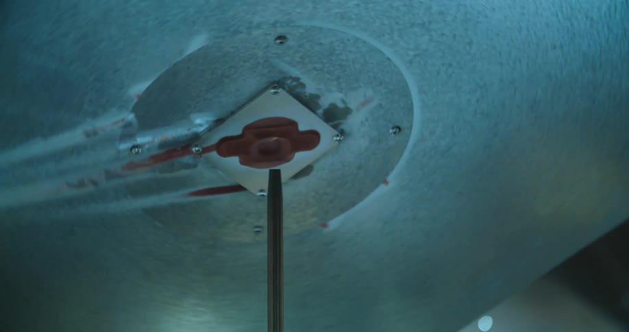A piece of metal is being spun around on a needle