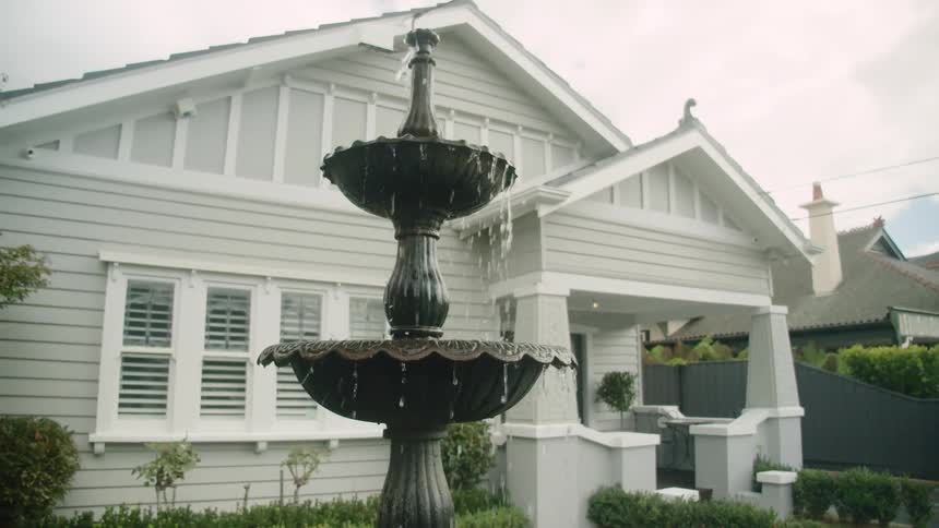Water pouring from a fountain on a house front porch