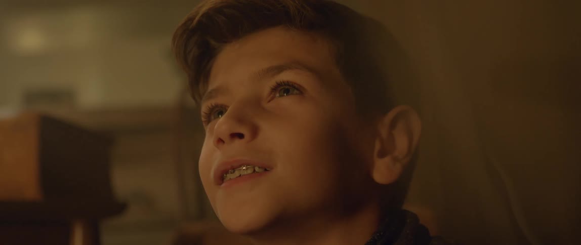 A boy is looking up and smiling
