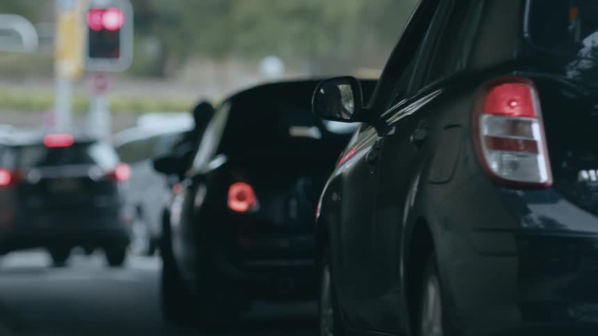 Vehicles pull up to red light at intersection