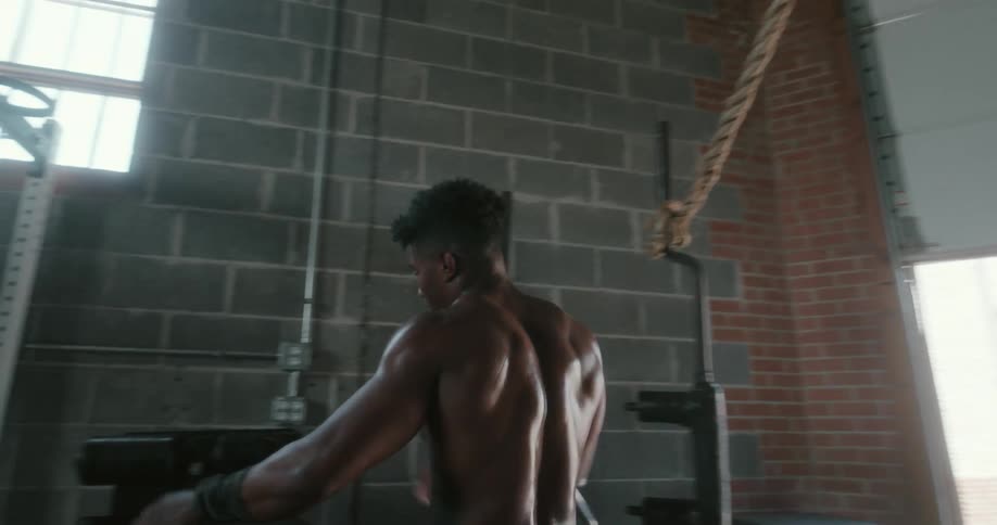 A man moves to a new piece of equipment in a gym