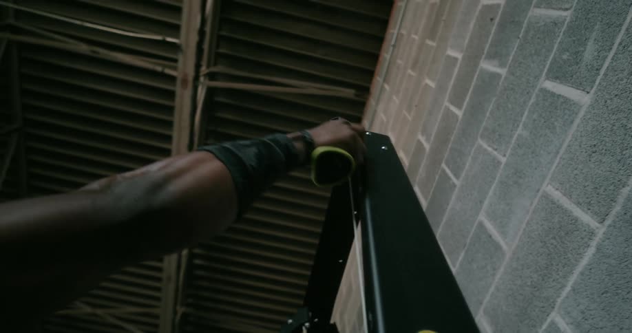 A man in a room exercising with a wall and window in the background