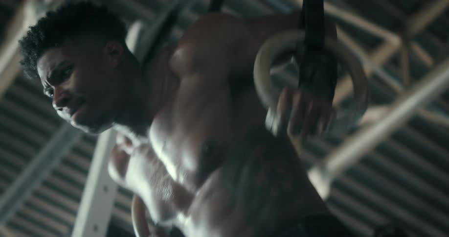 Shirtless muscular man does cross training in the gym