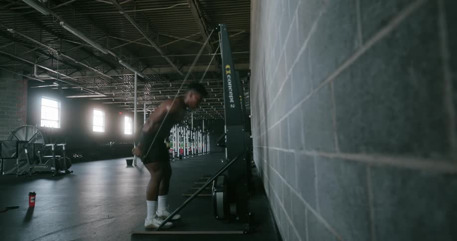 A man pulls ropes as he exercises