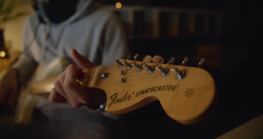 A man playing a guitar indoors