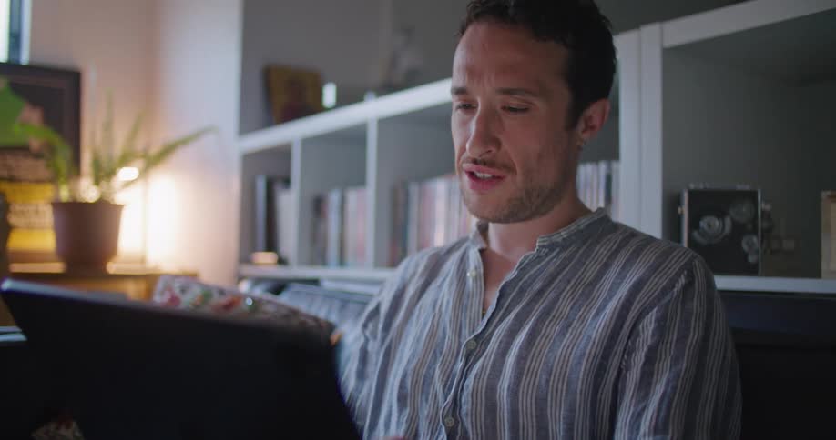A man talks to someone else via video chat on his tablet computer