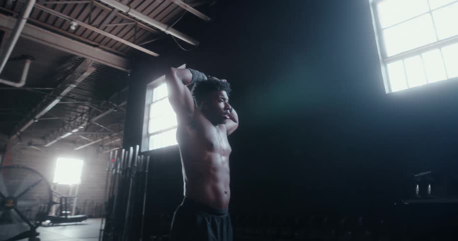 A man walks back and forth sweating as he rests from a workout