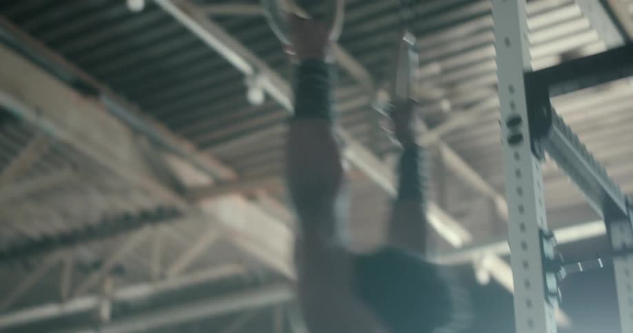 A male gymnast attempts a maneuver on rings