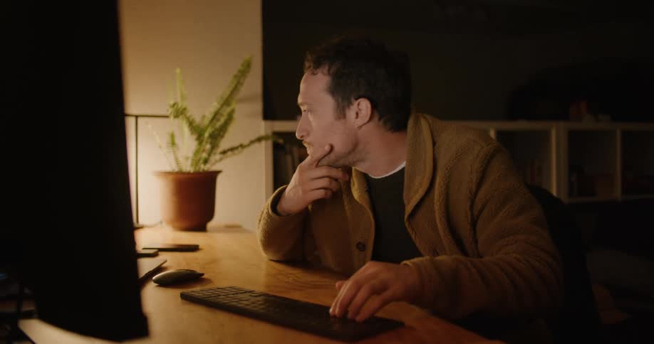A man sitting in an office working on a computer