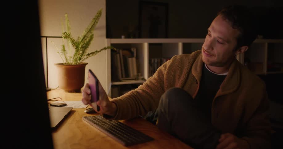 A man getting up from a desk with a computer at it