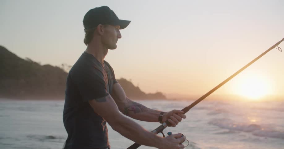 A man fishing on the edge of a beach