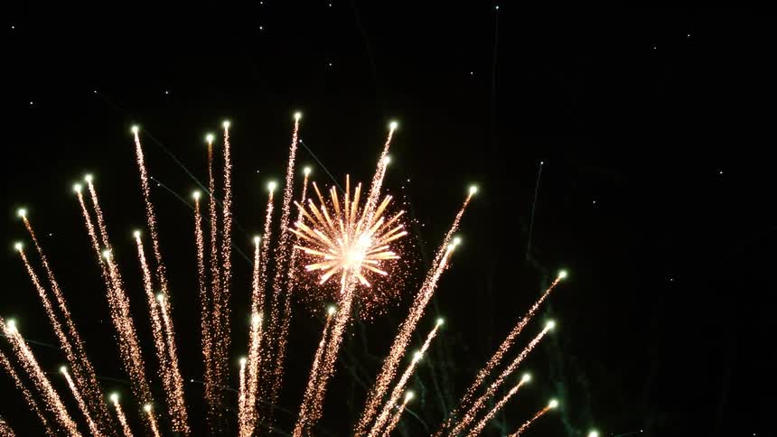 Fireworks are exploding in a dark night sky filled with stars