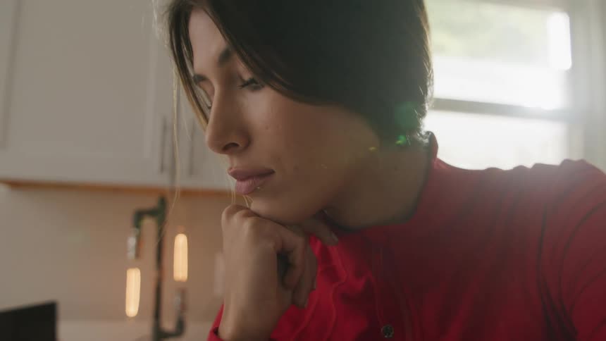 A woman sitting and thinking in a kitchen