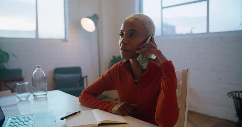 A woman chats on her smart phone while sitting at her downtown office