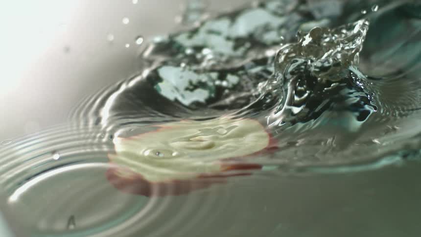 An apple slice falling into water would ripples bubbles and droplets