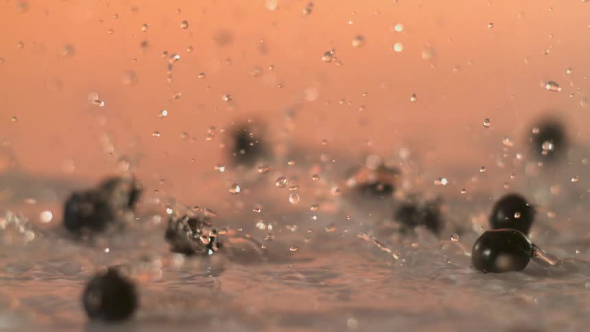 Fruit being tossed into water with droplets