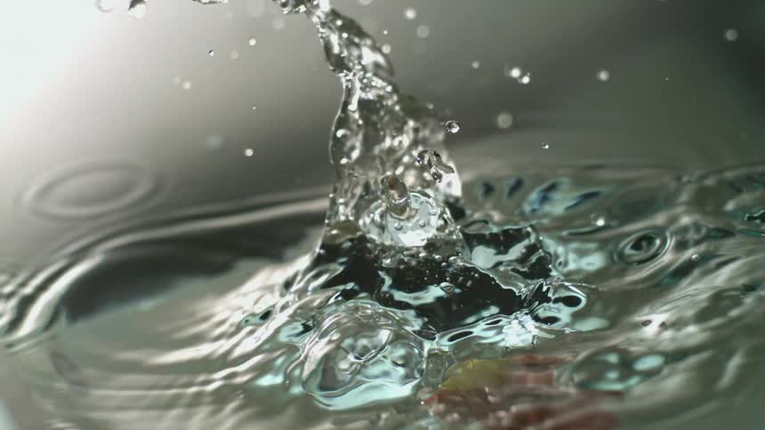 Water splashes as an apple slice falls in
