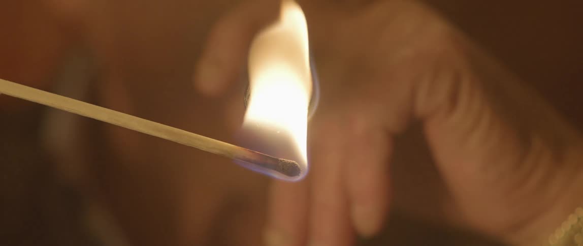 A match lights up a cigar