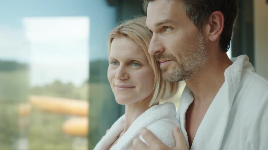 Two people standing at a window looking out