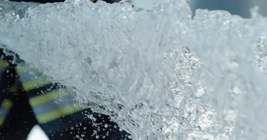 Strong spray of water pouring out a hole in a container
