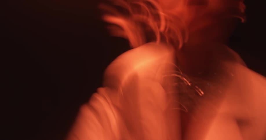 Woman dances and moves under red colored lights