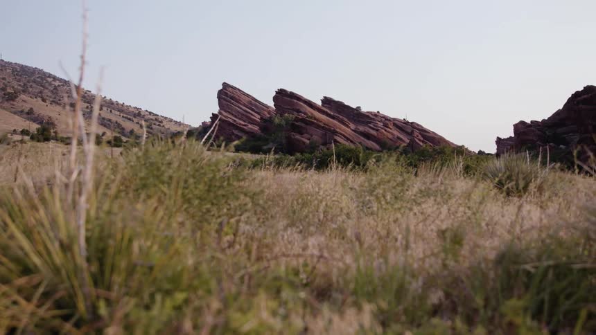 A landscape with grass with cliffs and hills the sky and clouds in the background