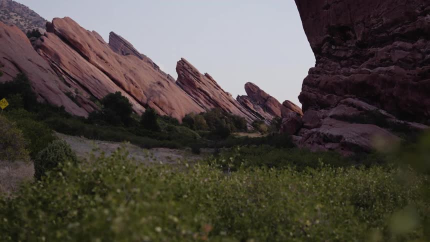 Mountain peaks jut up from a valley filled with trees and grasses