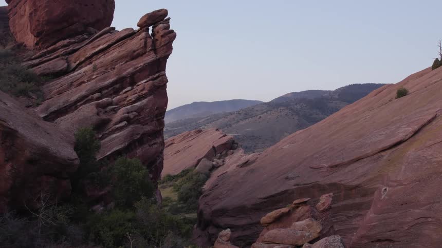 Reddish rock formations are stacked in a mountain wilderness area