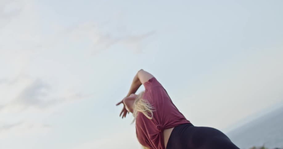 A woman doing yoga along a cliffside