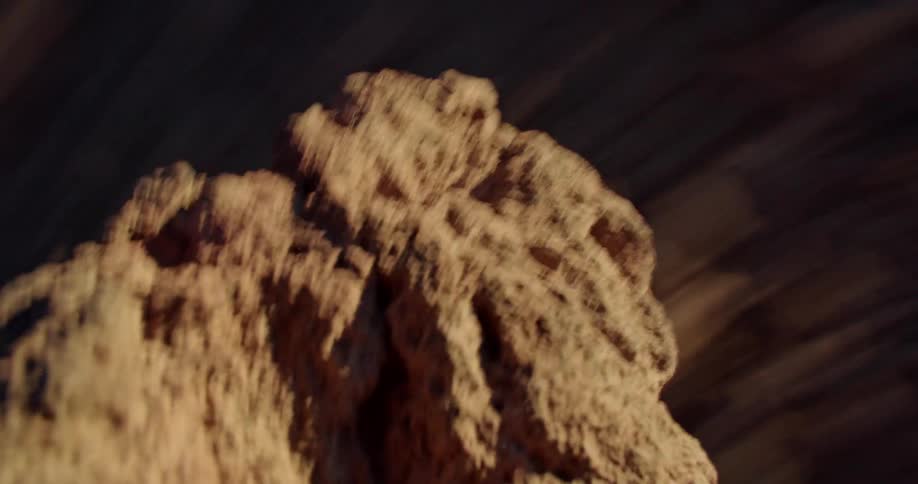 The focus is on a rock as mountains in the distance are spinning by quickly