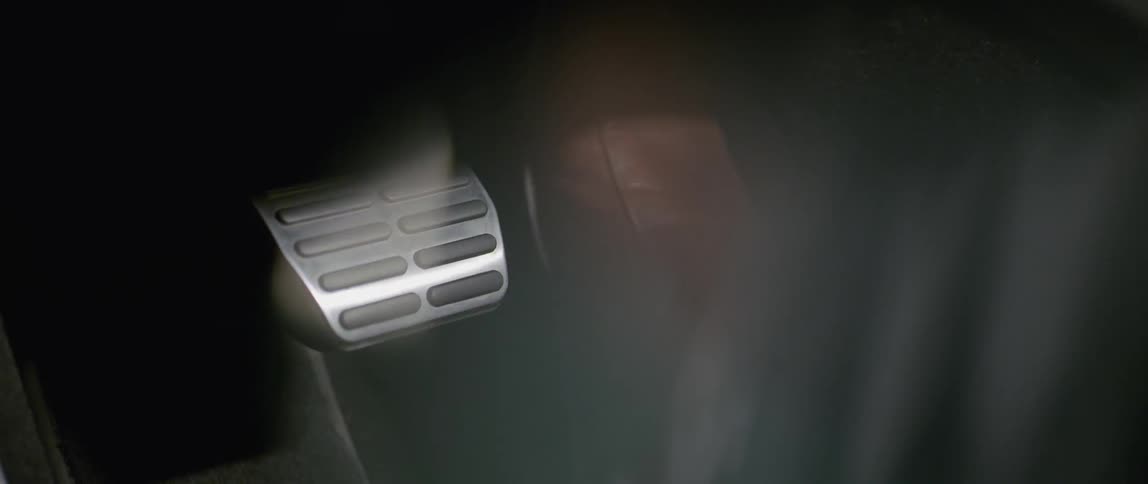 A person presses the gas pedal in a car