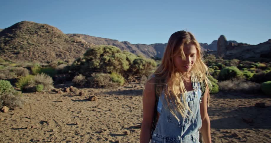 A young woman takes in the views as she hikes alone through a canyon