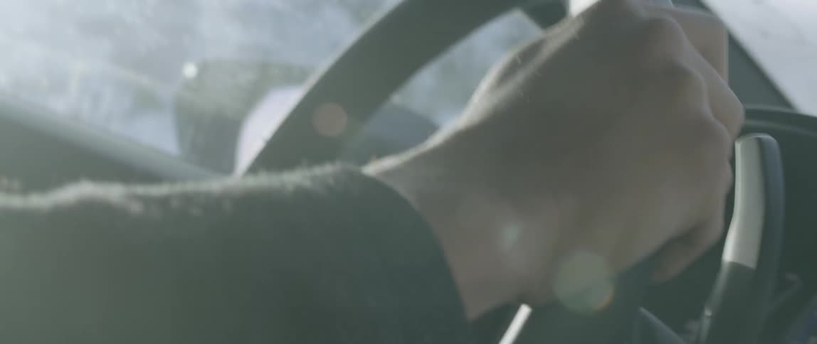Close up of hands steering a vehicle