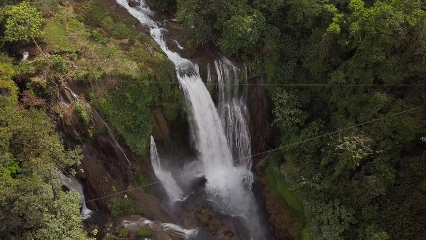 Aerial shot of a waterfall in a forest