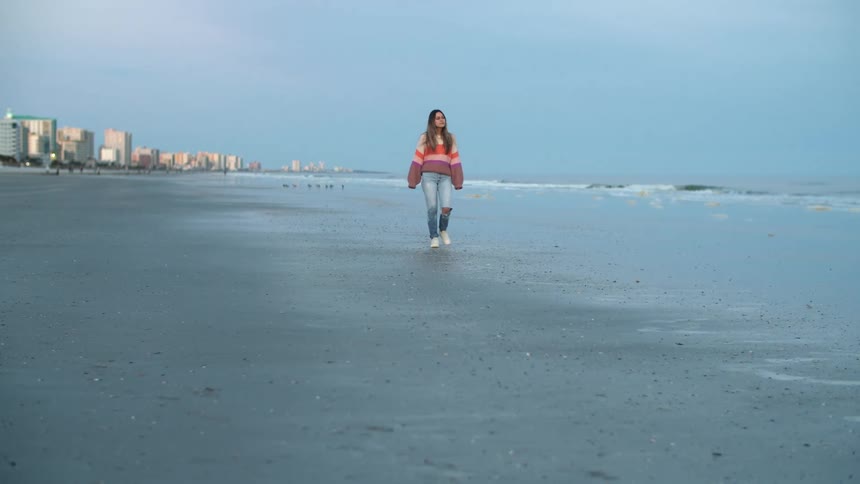 A woman is walking on the beach in spring