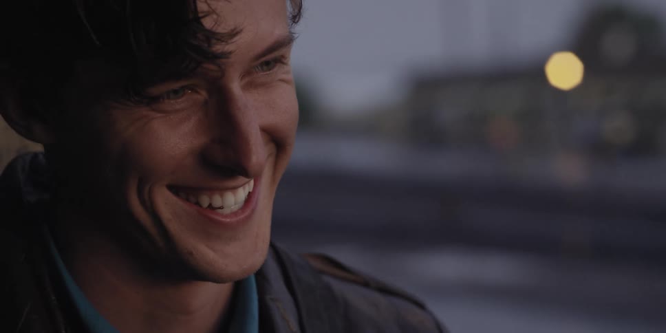 A man looks up as he smiles and laughs