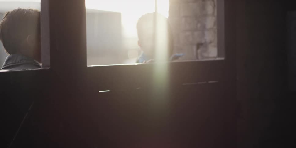 A couple of men open the door of a warehouse on a rainy morning