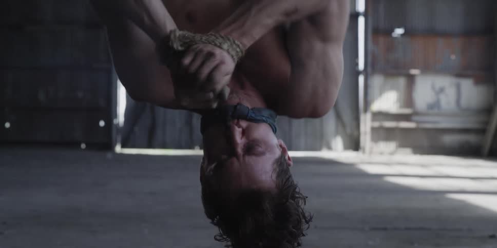 A man is hanging upside down against his will