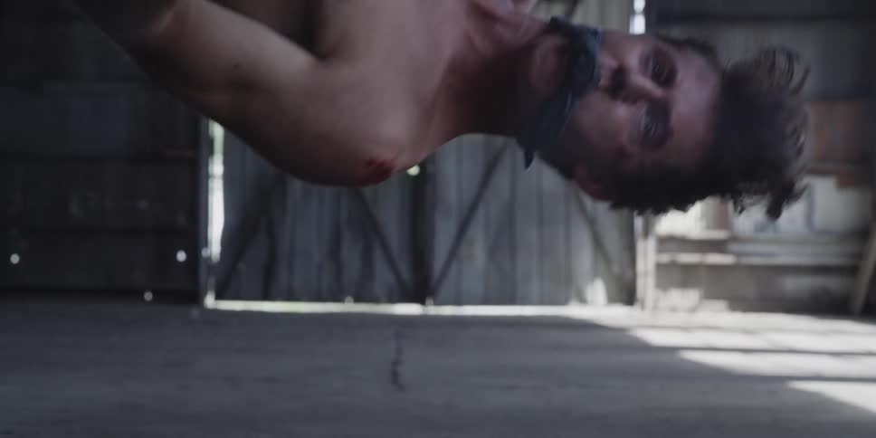 A man tied up hanging in a warehouse