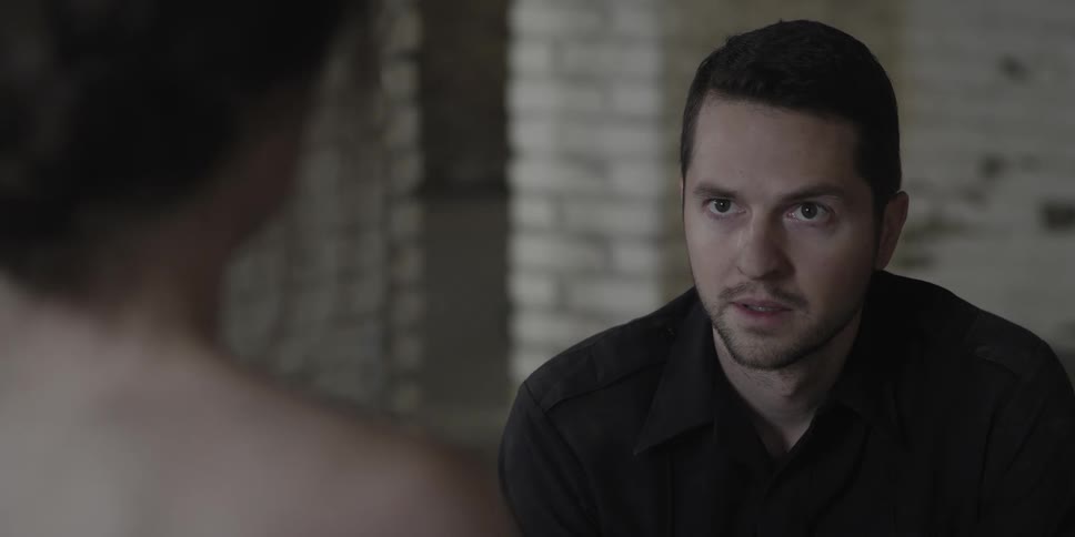 A man sits down across from a woman as they speak with one another