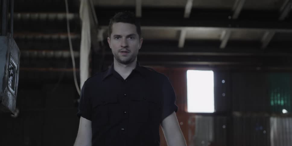 Man walks inside a warehouse looking at the camera