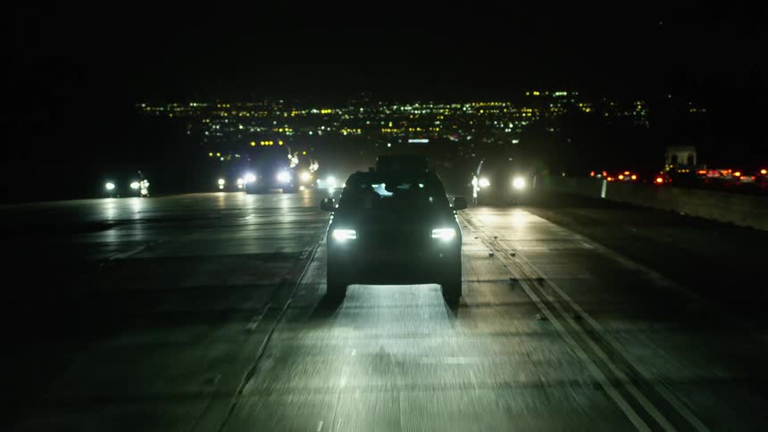 Cars driving down a highway at night