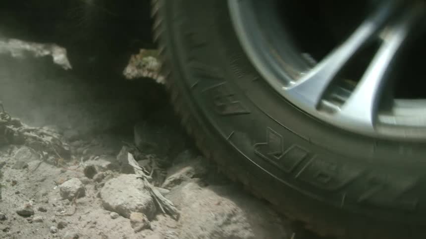 A vehicle makes its way up a rocky dirt road