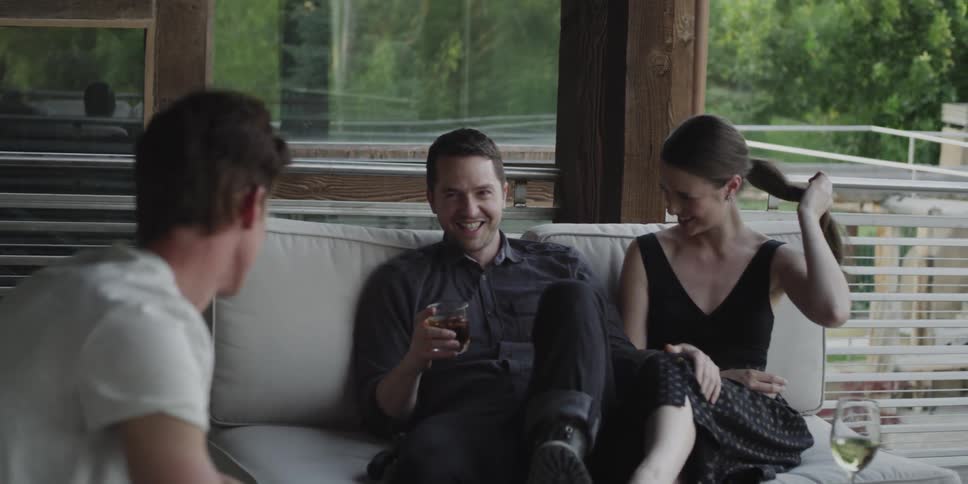 Friends talking and laughing sitting on the couch at home