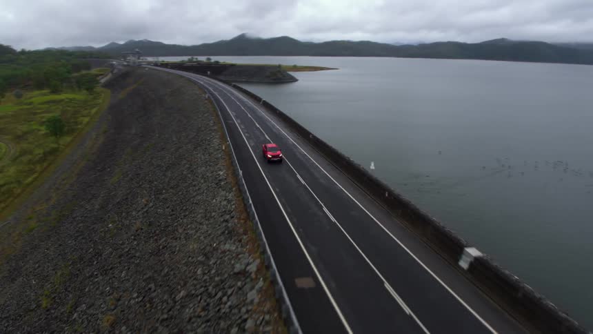 A truck drives along a road on the shore