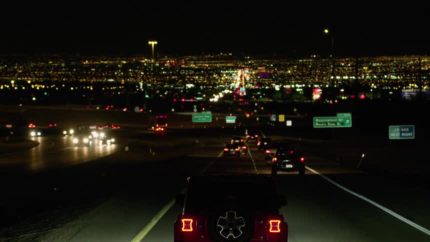 Cars driving on a highway close to the city at night